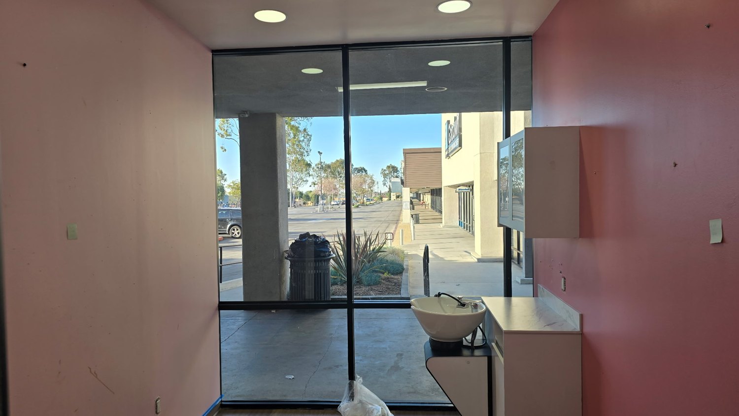 Pink and light-colored walls around a glass entrance in an interior